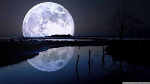 ماه بزرگ در آسمان شب و انعکاس تصویر آن در دریاچه 1