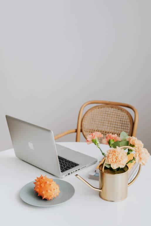 گلهای لپ تاپ MacBook و گلهای نارنجی (گل میخک یا گل میخک) روی میز ، میوه کیوانو 1