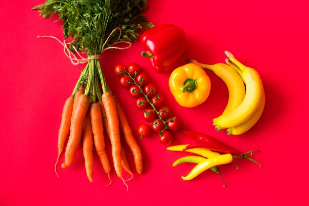 هویج گوجه فرنگی فلفل دلمه ای فلفل قرمز موز پس زمینه قرمز عکس غذا  تصویر زمینه 1